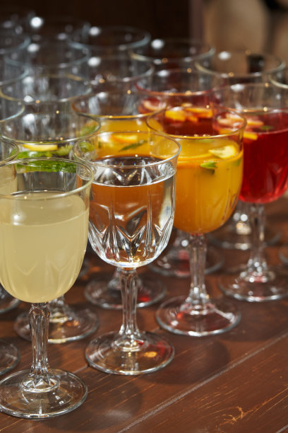 装有鸡尾酒的玻璃杯在桌子上。杯子里五颜六色的饮料图片下载