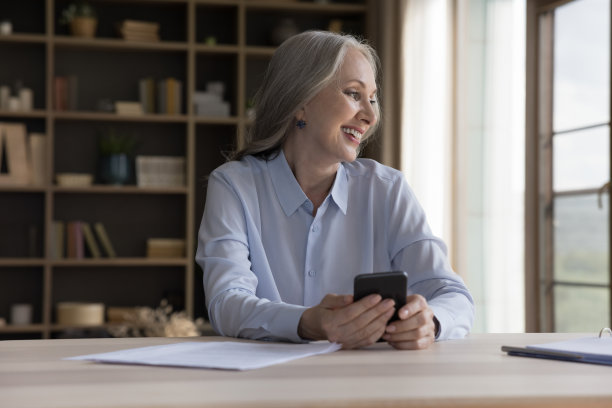 快乐年长灰色头发手机用户女人拿着手机图片下载