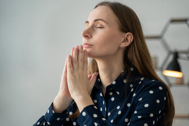冥想的概念。一位美丽的年轻女子正以冥想的姿势坐着，双手合十，做着祈祷的姿势，享受着宁静的氛围图片下载