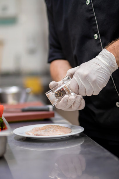 近距离的专业厨师准备鸡肉在餐厅厨房。烹饪概念图片下载