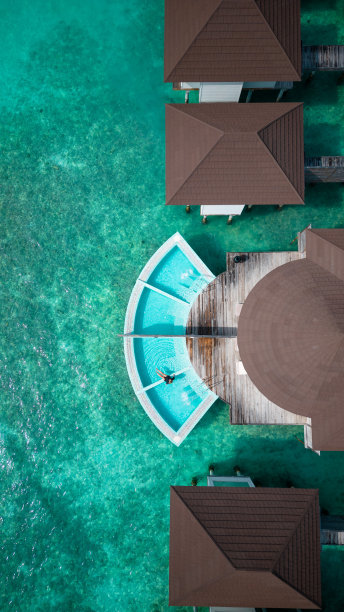 马尔代夫豪华酒店水上水疗别墅与女子坐在游泳池图片下载