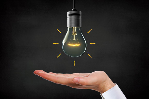 大创意，灵感和创新的灯泡概念在一个黑色的背景上的手掌图片下载