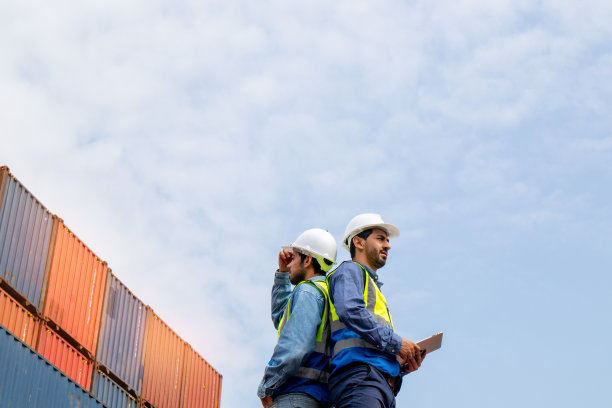 团队商人在集装箱运输公司检查货物，白人工人计划运输货物通过船舶分销商。图片下载