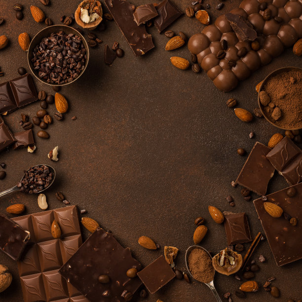以巧克力为背景，搭配巧克力块，巧克力片，坚果，可可图片下载