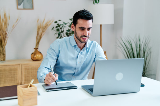 年轻人用记事本和笔记本电脑写字图片下载