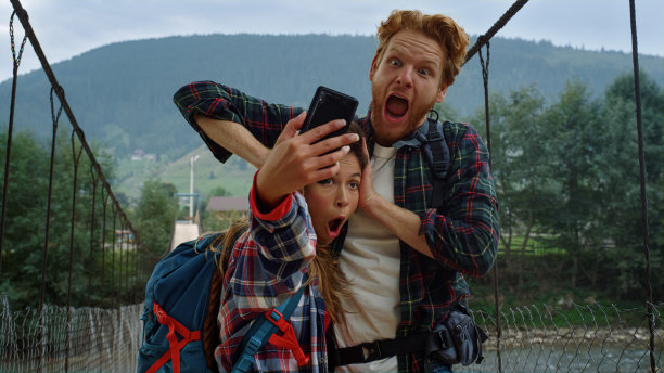 朋友们用智能手机自拍。游客夫妇在山上扮鬼脸图片下载