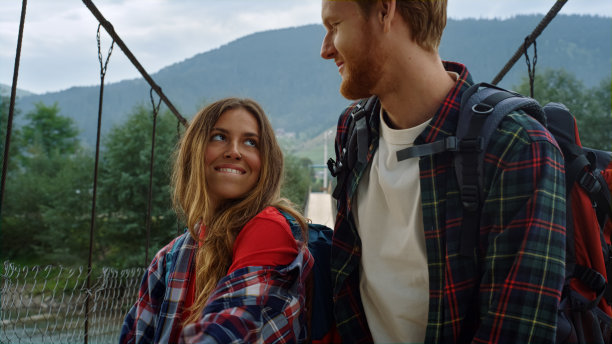 幸福的情侣在山桥上跳舞。情侣搭顺风车玩得很开心。图片下载