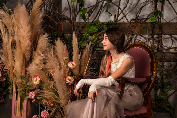 微笑优雅的少女时尚公主在浅粉色连衣裙坐在扶手椅神秘装饰的房间。时髦的少女看向别处。幻想艺术照片，童话概念。复制文本空格图片下载