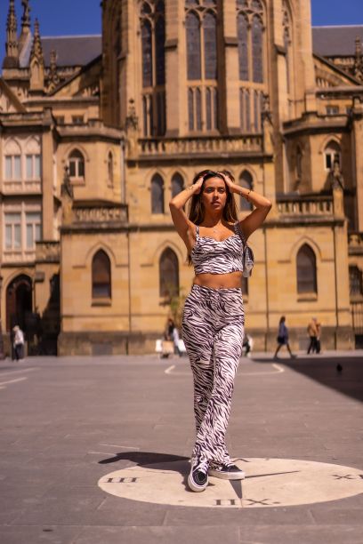 夏天，年轻的黑发女子穿着斑马印花连体裤在教堂旁图片下载
