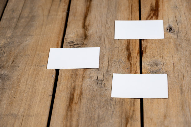 木制背景的三张空白名片。白色的长方形纸躺在有裂缝的旧木板上。有选择性的重点。图片下载