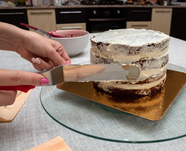 用厨房抹刀把奶油涂在蛋糕上。有选择性的重点。图片的文章，食品，烹饪，糖果。图片下载