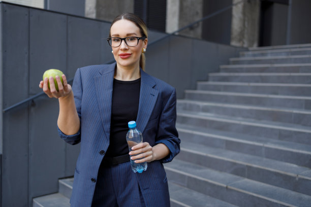 手持苹果和一瓶水的女商人肖像图片下载