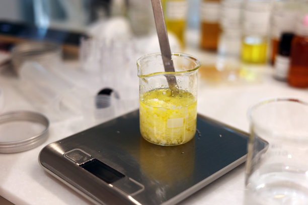 在烧杯中混合油和蜂蜡，在实验室中用电子秤称烧杯中的成分图片下载