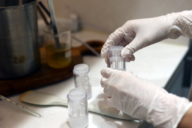 戴着手套的手在实验室里拿着化妆品空瓶图片下载