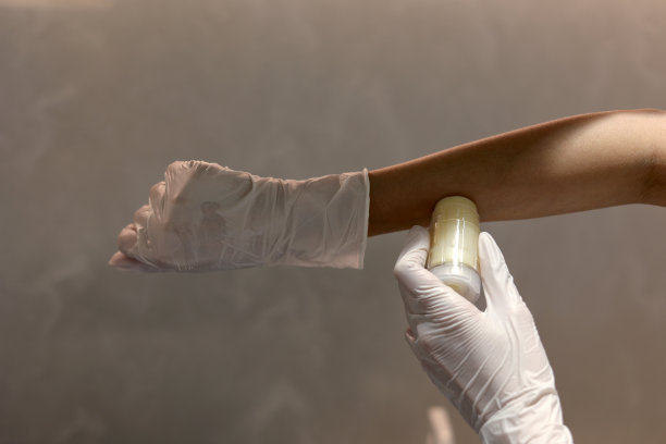 戴着手套的手在实验室里使用化妆品香脂瓶图片下载