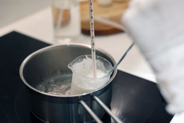 将烧杯中的水和荷荷巴油放入沸水中加热，用温度计记录温度图片下载