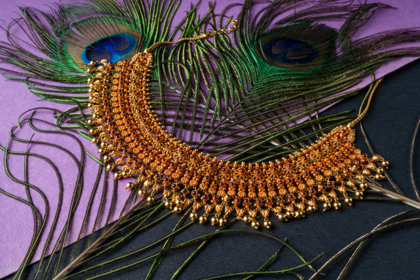 紫色纺织品上的金项链的特写镜头图片下载