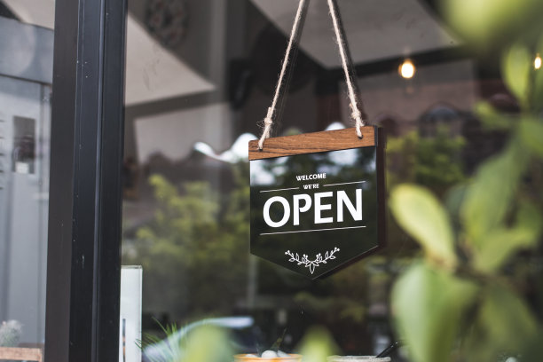 在咖啡馆里，复古的黑色标志上写着“进来，我们开门”。图片下载