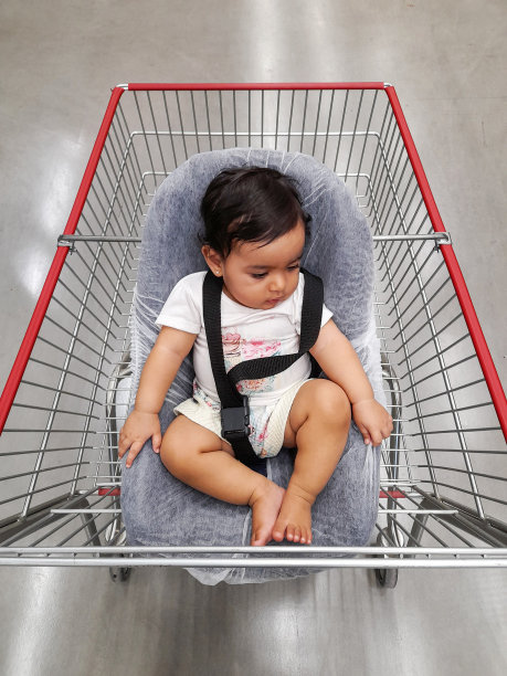 孩子，宝宝和爸爸妈妈在超市购物。
婴儿躺在婴儿车的座位上。图片下载