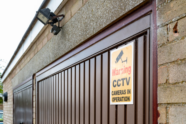 一个小区车库门上的闭路电视标志的浅焦点。图片下载