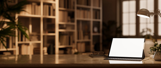 现代时尚的工作空间与平板电脑模型在桌面模糊的图书馆背景图片下载