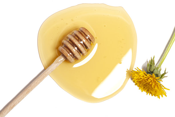 木制勺与蜂蜜和蒲公英孤立在白色的背景。黄金有机花蜂蜜天然。图片下载