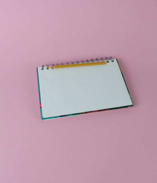 螺旋笔记本，黄色铅笔，粉红色背景。图片下载