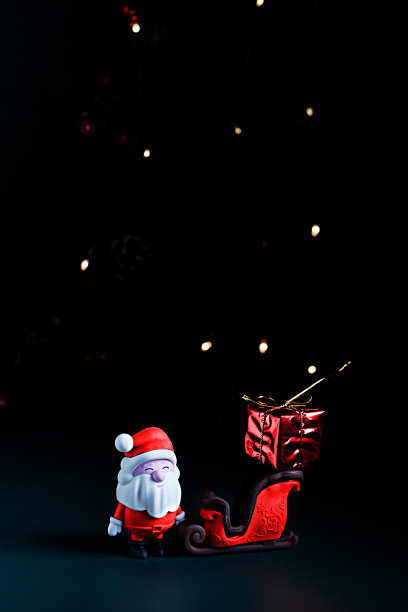 垂直拍摄圣诞老人的雪橇和礼物在黑暗的背景与灯光图片下载