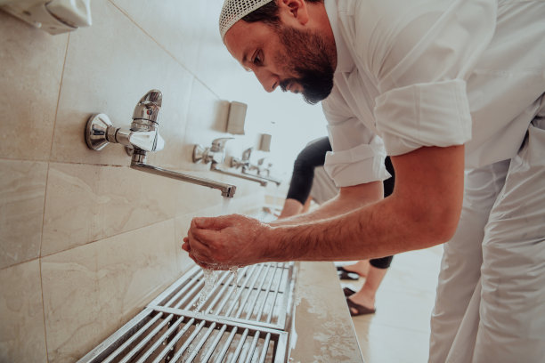 正在进行沐浴的穆斯林。穆斯林祈祷前的宗教清洗仪式。祷告:在祈祷前净化身体的过程图片下载