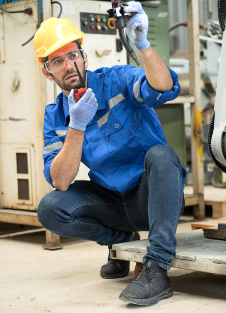 技术人员检查机械臂自动焊枪机，以控制制造中的焊接过程。图片下载