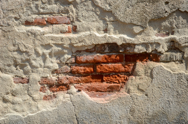 由于地震或年久失修，水泥剥落的旧砖墙。图片下载