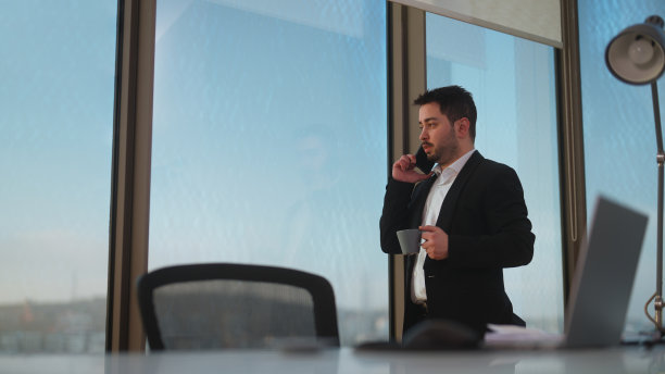 年轻的商人在办公室工作，打电话图片下载