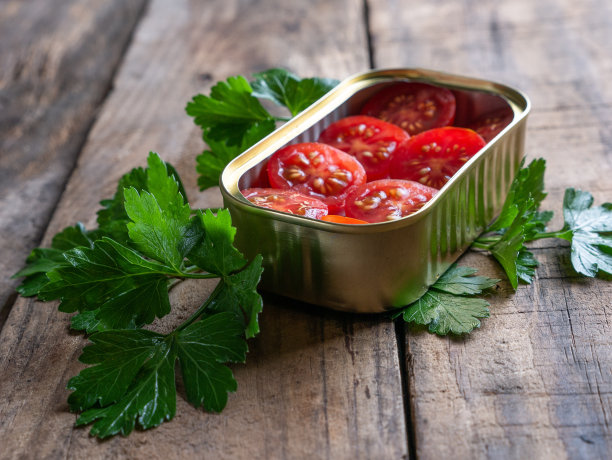 圣女果放在罐头里，欧芹单独放在木桌上图片下载