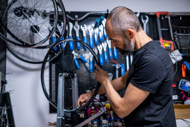 一个自行车钳工在平衡车轮。图片下载