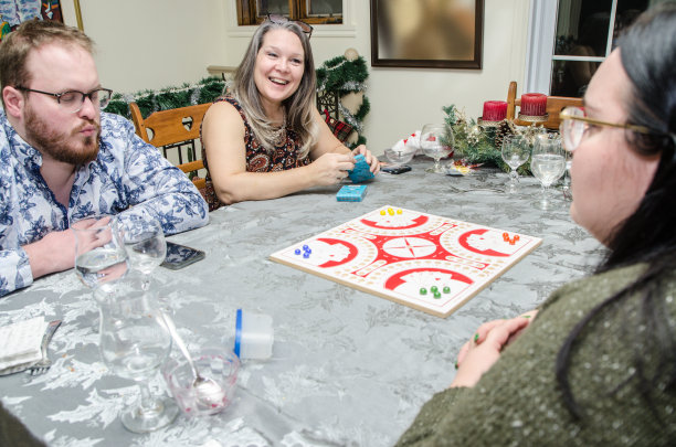 母亲和成年孩子在玩棋盘游戏图片下载