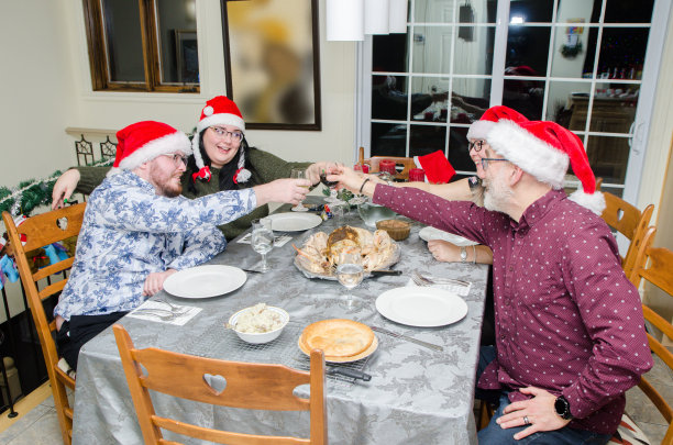 圣诞家庭围坐在餐桌旁敬酒图片下载