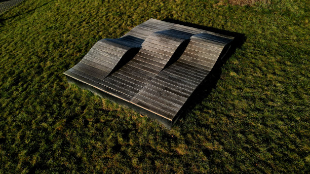 由木板和木板制成的三波甲板椅。景观公园中的大型座椅元素。老人家具，鸟瞰，绿地，三部分，无人机视角，海滩图片下载