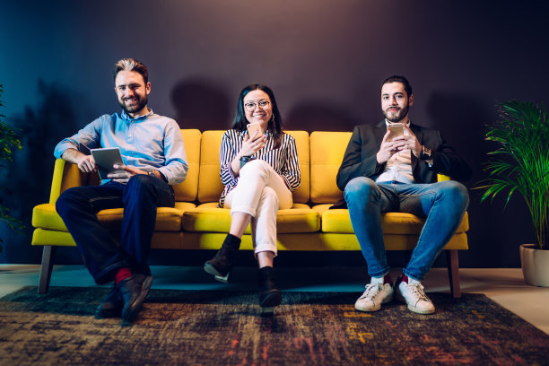 欢快的人们坐在沙发上摆弄着小玩意儿图片下载