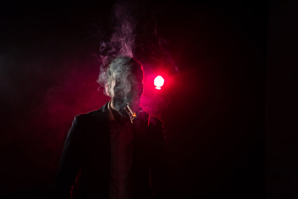 粉红色背景上吸烟男子的照片。图片下载