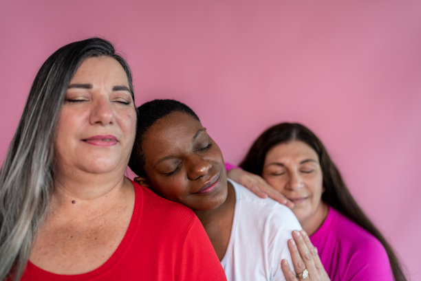 粉红色背景下闭着眼睛的成熟朋友图片下载