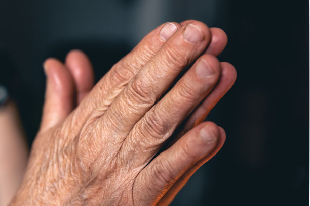 一位老妇人双手合十祈祷。图片下载