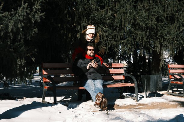 在冬天的公园里，女人正在取男人脖子上的围巾图片下载