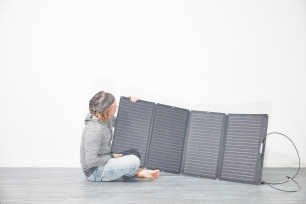 男子与移动太阳能电池板前的白墙图片下载