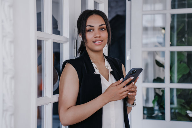 近距离肖像的非裔美国妇女在家里看着相机与可爱的微笑。自信漂亮的巴西女孩在办公室休息。模仿快乐的人。满意女学生之家图片下载