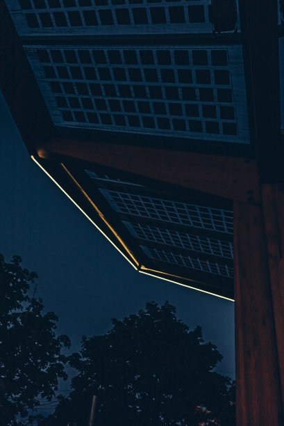 夜晚，微弱的灯光照亮了房屋屋顶的边缘图片下载