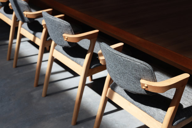 会议室里的空椅子和长桌的高角度视图。阳光落在空木椅上。图片下载