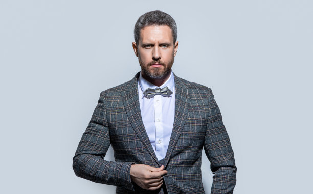 男士肖像穿燕尾服正式西装。穿燕尾服的人被隔离在灰色背景中。图片下载