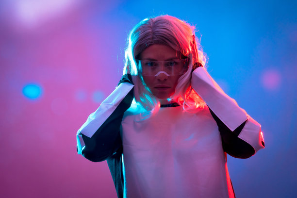 美丽的女人透过未来的眼镜，黑暗的背景，未来和虚拟现实的概念图片下载