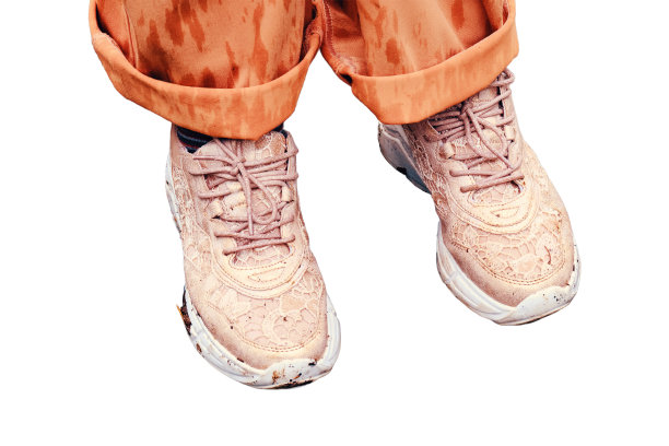 穿着橙色鞋子的孩子们的脚站在春天的小溪里，在白色的背景上显得孤立图片下载