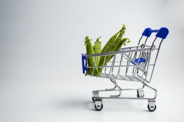 迷你购物车里的青豆孤立在白色背景上图片下载